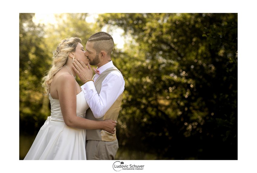 Photographe de mariage photographiant un couple en extérieur lors d’un reportage naturel